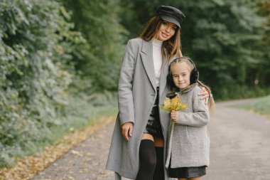 Sonbahar parkında şirin ve şık bir aile.