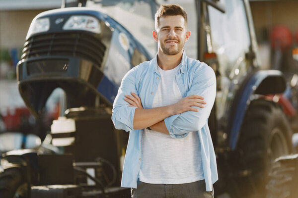 Male standing by the blue tractor