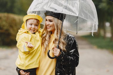 Yağmur parkında oynayan çizmeli komik çocuklar.