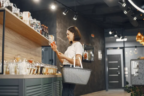 Schöne Frau im Laden kauft Lebensmittel. — Stockfoto