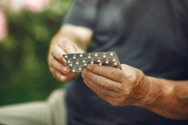 Portrait of helderly man holding pills