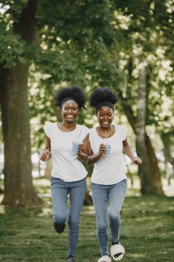 İkiz kardeşler ellerinde bardaklarla kameraya koşuyorlar.