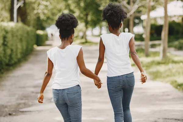 Deux sœurs afro-américaines se tenant la main et marchant dans un parc — Photo