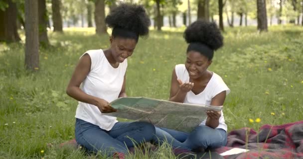 Amigas africanas con un mapa en el parque — Vídeo de stock