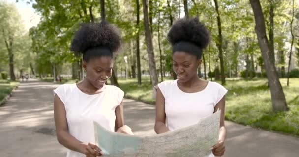 Afrikanische Freundinnen mit Landkarte im Park — Stockvideo