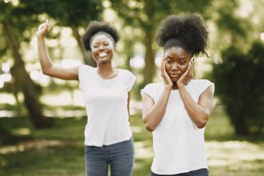 Parkta fotoğraf çektirmek için poz veren Afro-Amerikan kardeşler.