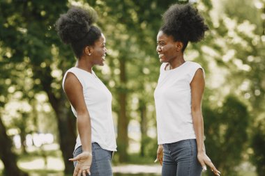 Parkta durup birbirlerine bakan ikiz kardeşler.