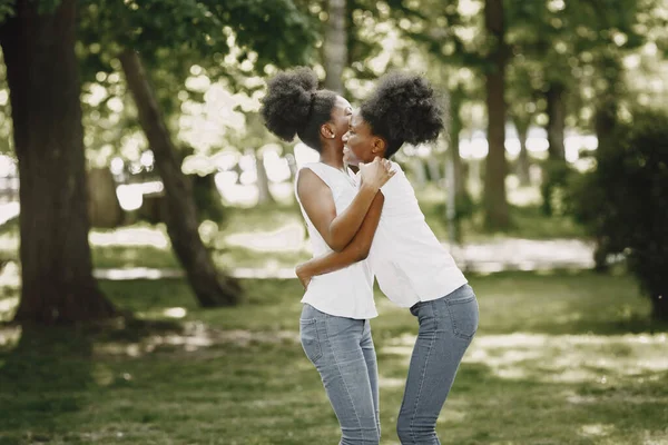 Parkta sarılan iki Afro-Amerikalı kız kardeş. — Stok fotoğraf