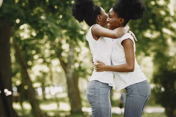 Parkta sarılan iki Afro-Amerikalı kız kardeş. — Stok fotoğraf