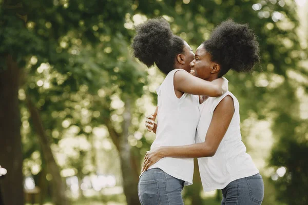 Parkta sarılan iki Afro-Amerikalı kız kardeş. — Stok fotoğraf