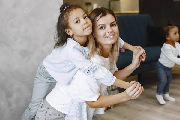 Gelukkige moeder en schattig dochtertje glimlachend en kijkend naar de camera. kind omarmen moeder liggend op haar rug. — Stockfoto