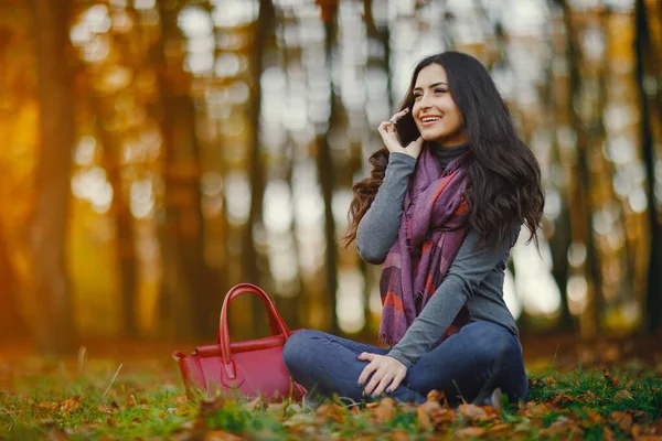 Brunetka dziewczyna przy użyciu telefonu w parku — Zdjęcie stockowe