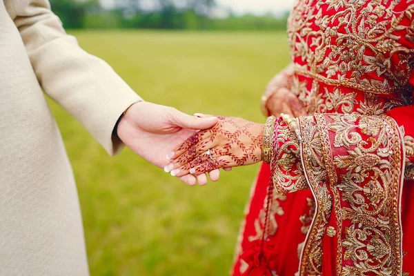 Hindu bride walks behind husband holding garb — Stock Photo, Image