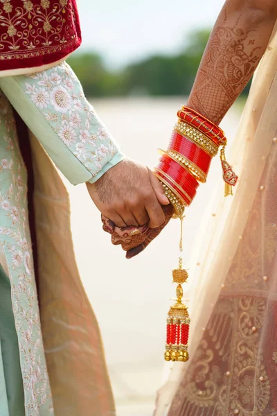 Hindu noiva caminha atrás marido segurando vestuário — Fotografia de Stock