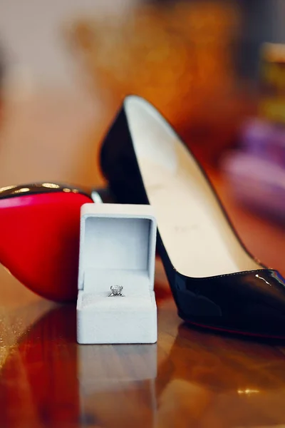 Wedding rings close up on brides shoes. — Stock Photo, Image