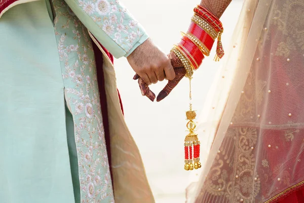 Novia hindú camina detrás de marido sosteniendo atuendo —  Fotos de Stock