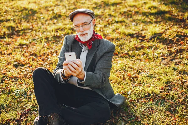 Vieil homme élégant dans un parc d'automne ensoleillé — Photo