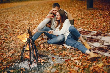 Zarif çift sonbahar parkında vakit geçiriyor.