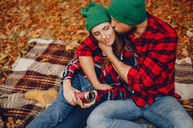 Zarif çift sonbahar parkında vakit geçiriyor.