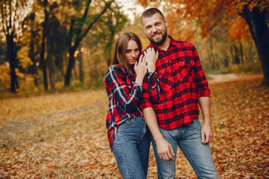 Zarif çift sonbahar parkında vakit geçiriyor.