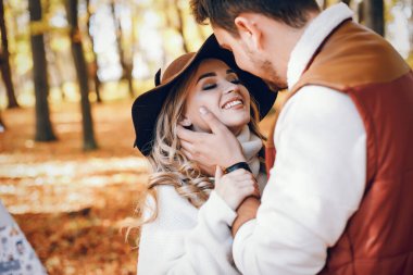 Güneşli bir sonbahar parkında zarif bir çift.