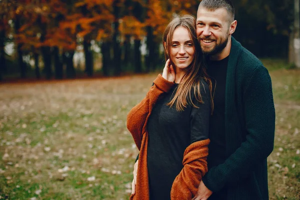 Casal elegante passar o tempo em um parque de outono — Fotografia de Stock