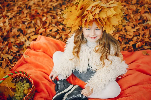 Sonbahar parkında küçük şirin bir kız.