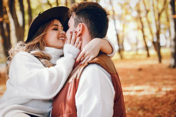 Casal elegante em um parque de outono ensolarado — Fotografia de Stock