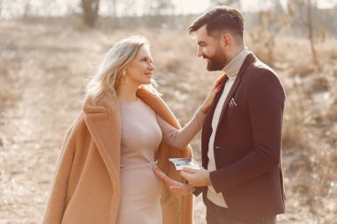 Kocasıyla parkta duran hamile bir kadın.