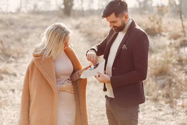 Kocasıyla parkta duran hamile bir kadın.