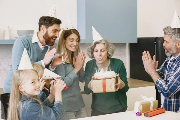 Família comemorando aniversário de sua avó na cozinha — Fotografia de Stock