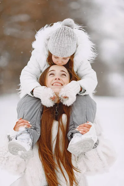 Anya és gyermek téli ruhában játszanak a téli parkban — Stock Fotó