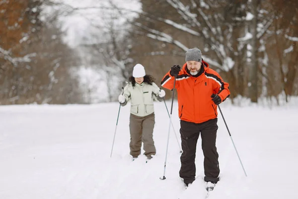 Senior couple skiing cross-country in a forest Stock Photo