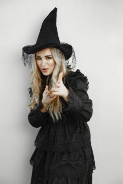 Siyah kostüm giyen kadın. Cadılar Bayramı makyajlı kadın. Beyaz arka planda bir kız.