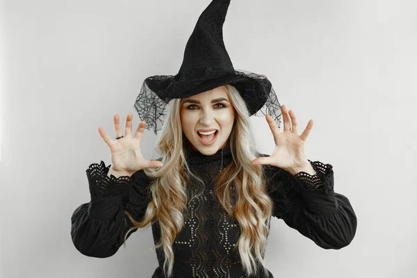 Uma mulher vestida de preto. Senhora com maquilhagem de Halloween. Menina em um fundo branco. — Fotografia de Stock