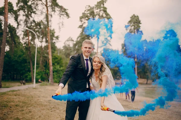 Svatební pár běží modrý kouř — Stock fotografie
