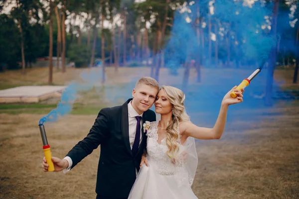 Svatební pár běží modrý kouř — Stock fotografie