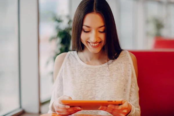 Hermosa chica joven disfruta del teléfono y la tableta — Foto de Stock