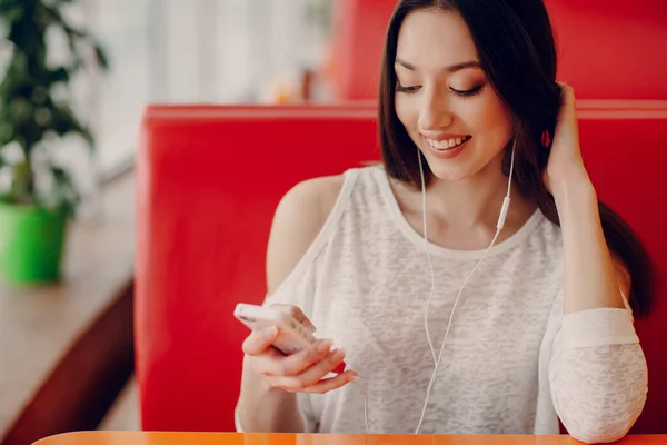 Hermosa chica joven disfruta del teléfono y la tableta — Foto de Stock