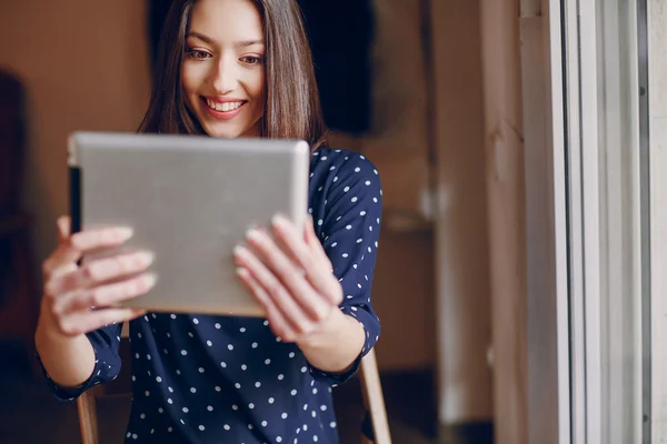 Hermosa chica joven disfruta del teléfono y la tableta — Foto de Stock