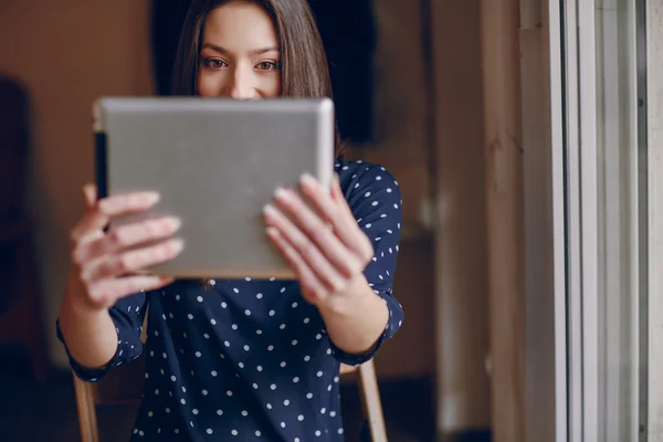 Hermosa chica joven disfruta del teléfono y la tableta — Foto de Stock