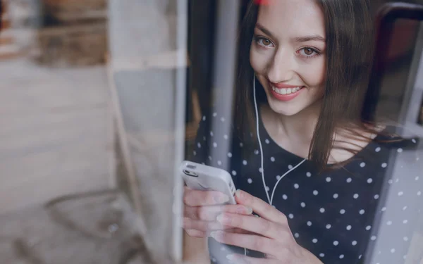 Hermosa chica joven disfruta del teléfono y la tableta — Foto de Stock