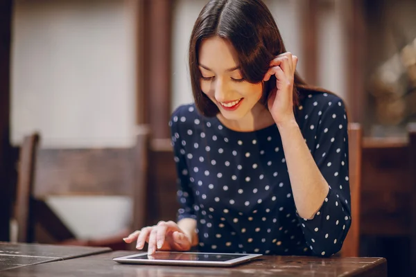 Hermosa chica joven disfruta del teléfono y la tableta — Foto de Stock