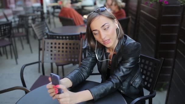 Krásná bruneta požívá miniaplikace venku — Stock video