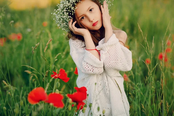 Beautiful little girl posing in a skirt  wreath of poppies — Stock Photo, Image