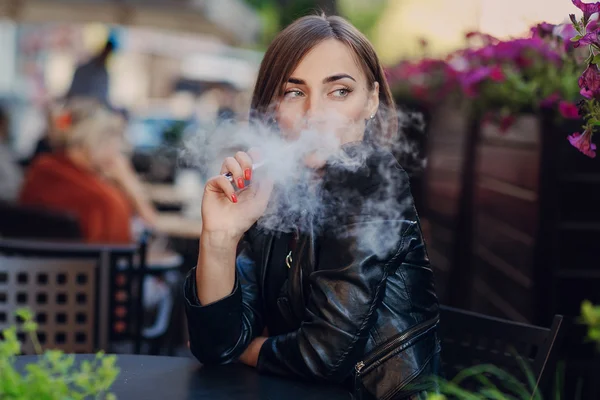 Krásné okouzlující brunetka dým elektronické cigarety — Stock fotografie