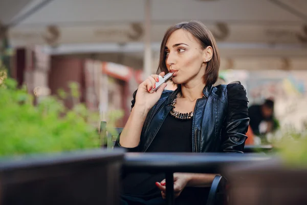 Krásné okouzlující brunetka dým elektronické cigarety — Stock fotografie