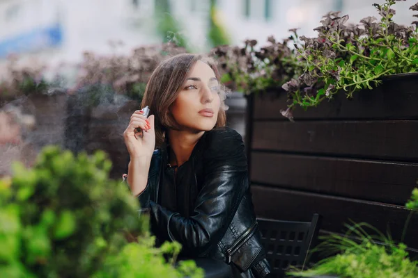 Krásné okouzlující brunetka dým elektronické cigarety — Stock fotografie