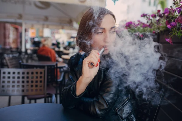 Schöne glamouröse Brünette raucht elektronische Zigarette — Stockfoto