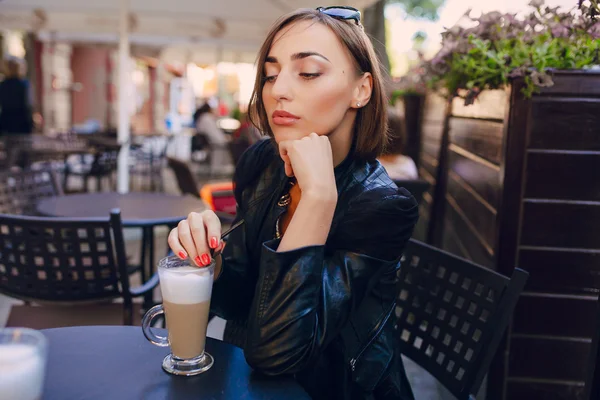 Hermosa chica bebiendo un capuchino en un café — Foto de Stock